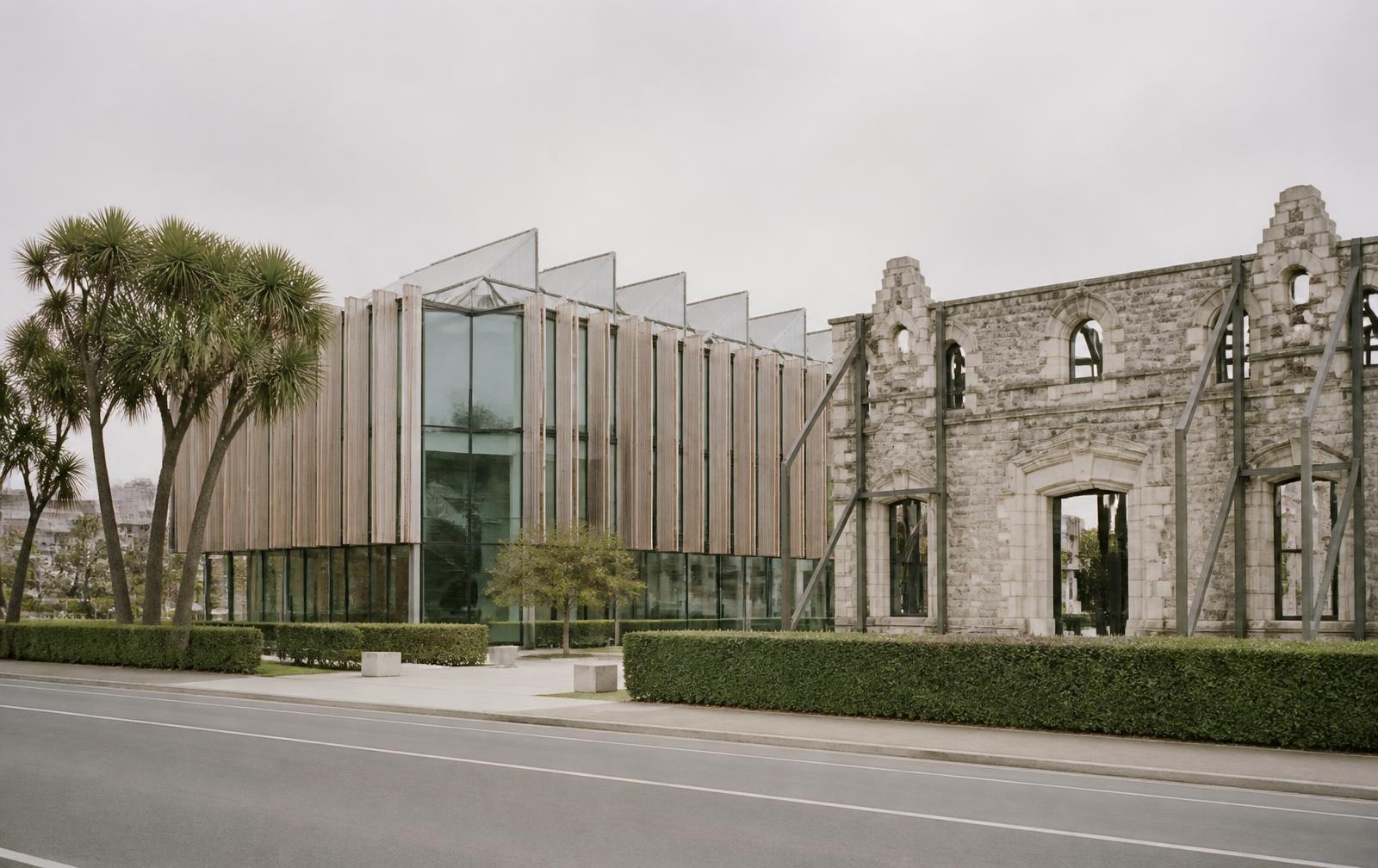 Christchurch rebuild architecture in timber and glass beside a braced stone facade on an empty street